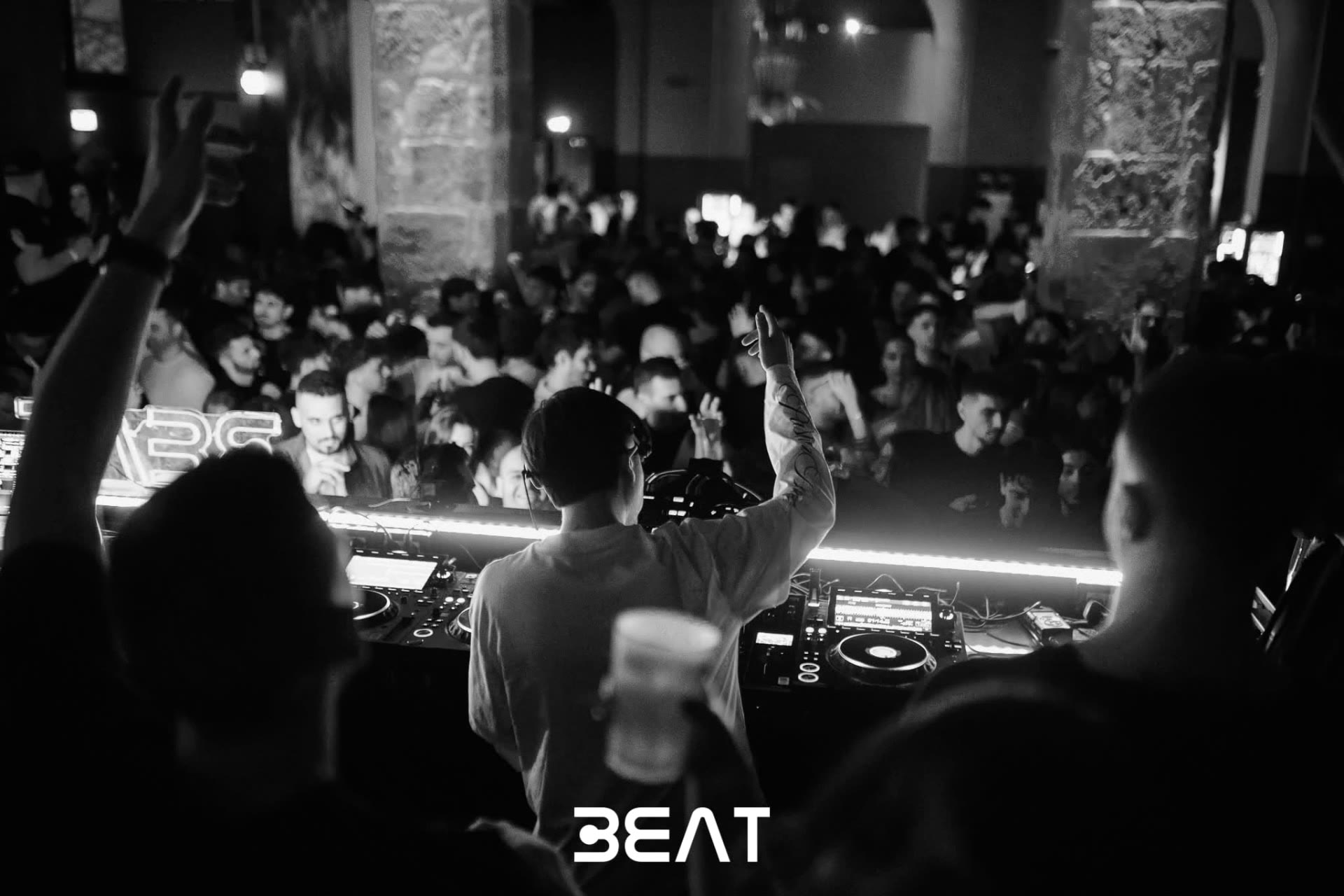 Il DJ di spalle davanti alla folla durante una serata BEAT