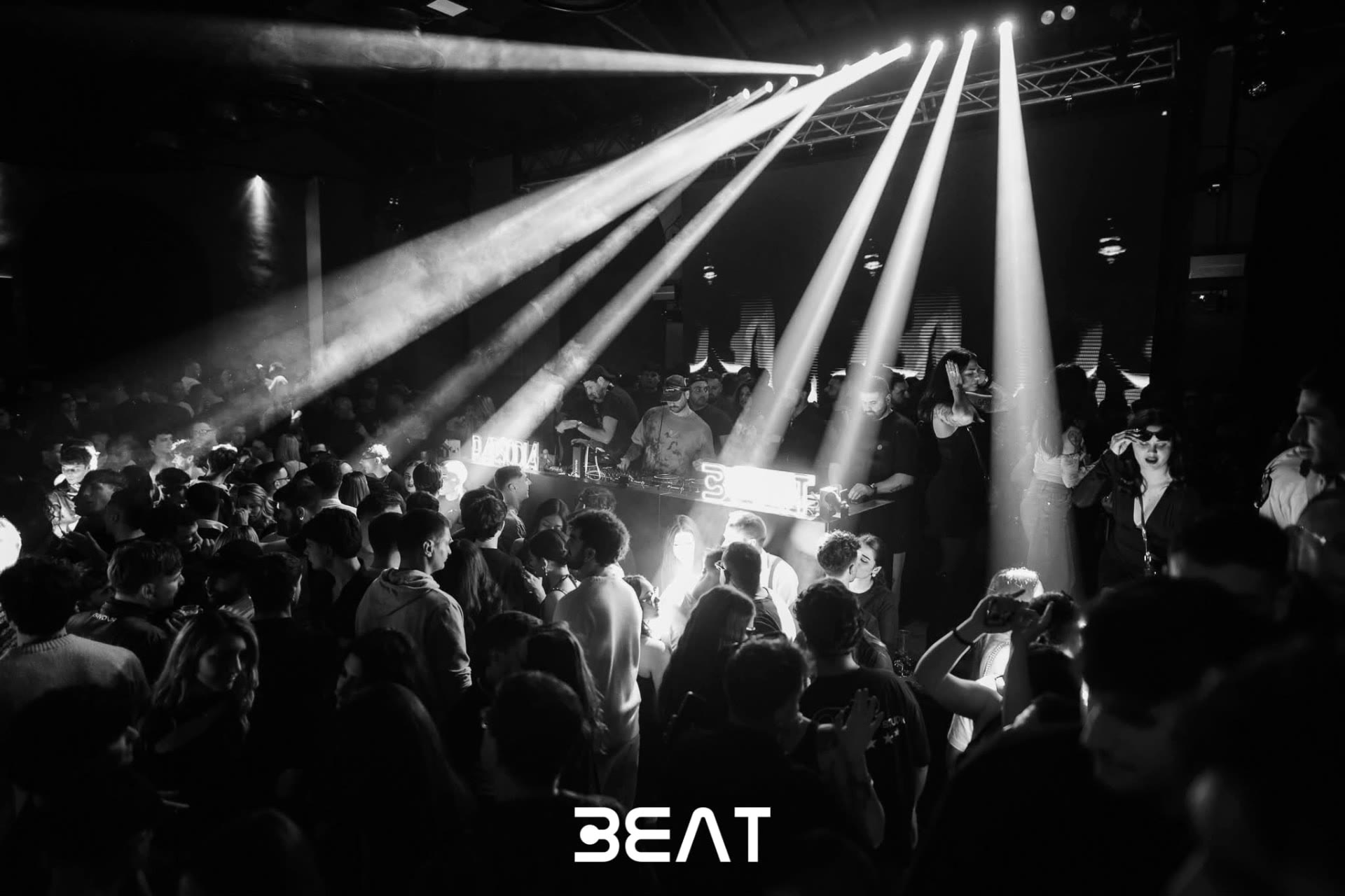 Fasci di luce bianchi sul pubblico durante una serata BEAT